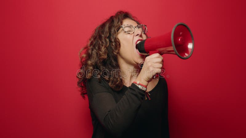 Een vrouw uit de middelbare leeftijd die boos is en megafoon gebruikt op rode achtergrond