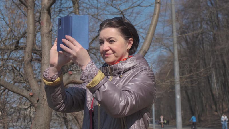 Een vrouw van middelbare leeftijd een brunette caucasiaanse race met kort haar staat op een observatiedek in een grote voetganger