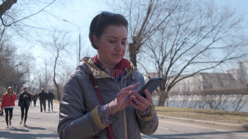 Een vrouw van middelbare leeftijd een brunette caucasiaanse race met kort haar staat op een observatiedek in een grote voetganger