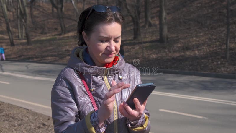 Een vrouw van middelbare leeftijd een brunette caucasiaanse race met kort haar staat op een observatiedek in een grote voetganger