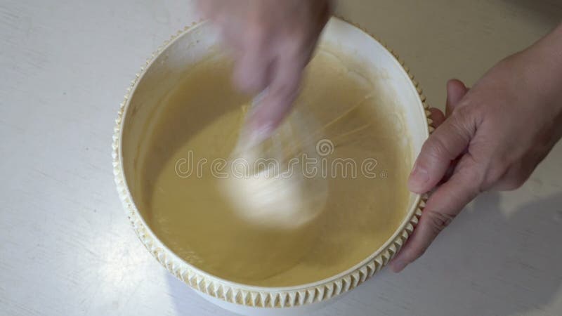 Een vrouw zweeft in een ronde kom in de keuken van het huis op een witte houten tafel .. het begrip koken