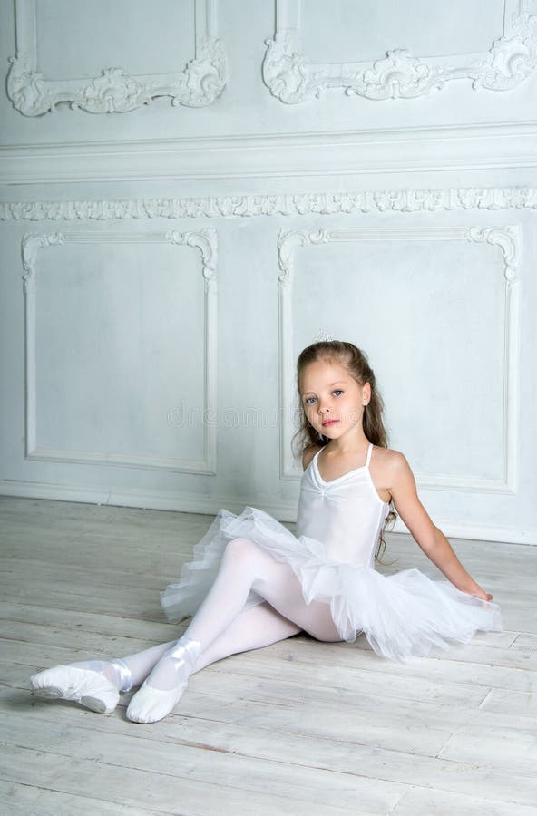 Een weinig aanbiddelijke jonge ballerina in een speelse stemming in inter