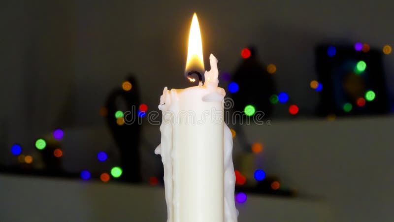 Een witte kerstkaars met vage lichten stock afbeeldingen