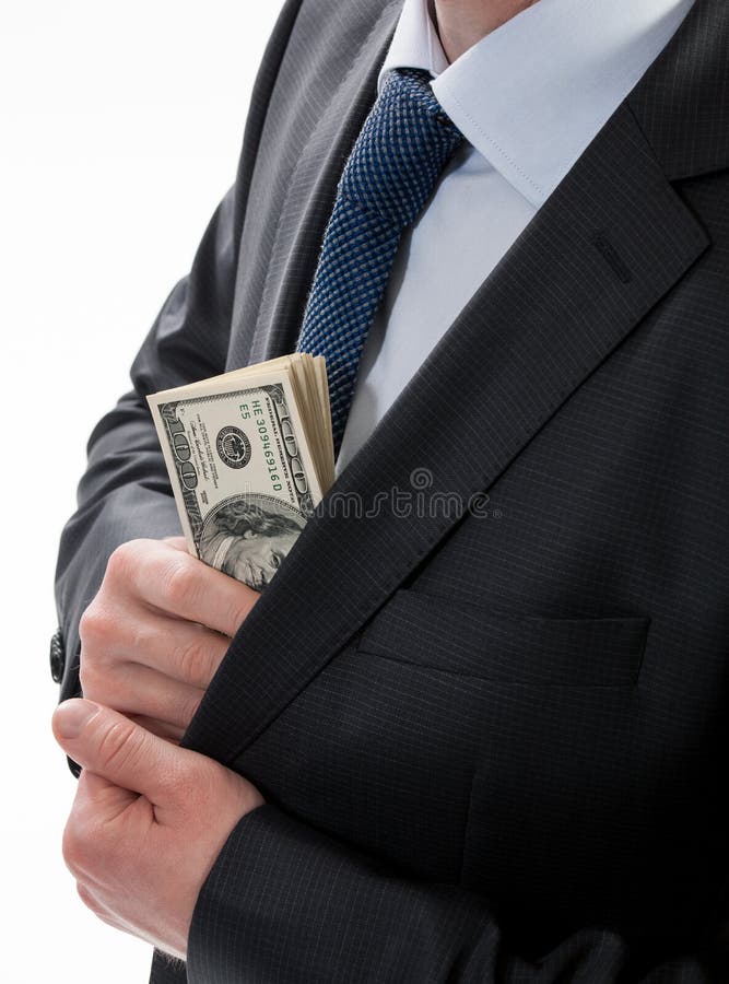 A businessman in a black suit putting money in his pocket isolated on white background. A businessman in a black suit putting money in his pocket isolated on white background