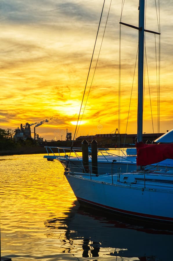 Een zeilboot met een mooie zonsondergang achter het stock foto Een zeilboot met een mooie zonsondergang achter het stock foto