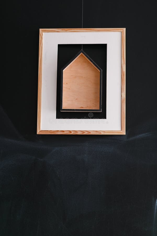 Eenvoudige moderne vierkante schilderijen met blokhuis het hangen op ruwe zwarte muur stock afbeeldingen Eenvoudige moderne vierkante schilderijen met blokhuis het hangen op ruwe zwarte muur stock afbeeldingen
