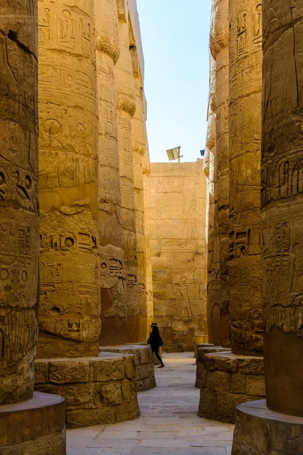 Eenzaam vrouwenfiguur onder de kolommen in de grote hypostyle zaal van de Karnak-tempel royalty-vrije stock fotografie Eenzaam vrouwenfiguur onder de kolommen in de grote hypostyle zaal van de Karnak-tempel royalty-vrije stock fotografie