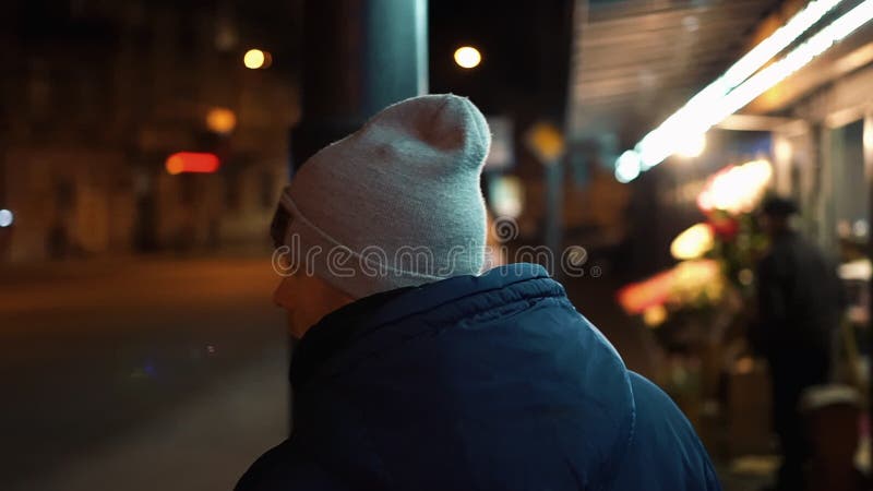 Eenzame jonge mensengangen rond de nachtstad