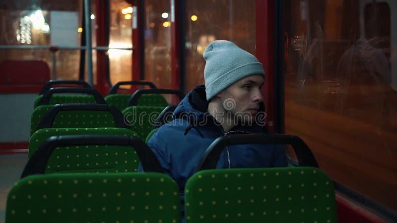 Eenzame jonge mensenritten in een tram in de nacht