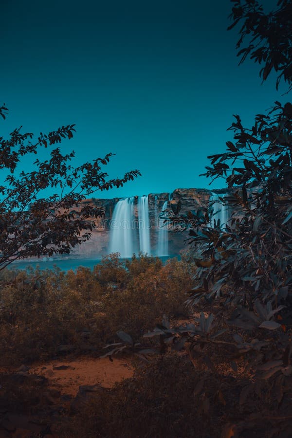 Eerie scenery of the Chitrakote Falls on the Indravati River behind trees in India