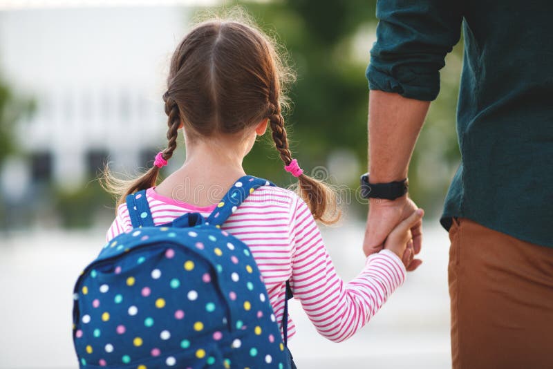 First day at school. father leads a little child school girl in first grade. First day at school. father leads a little child school girl in first grade