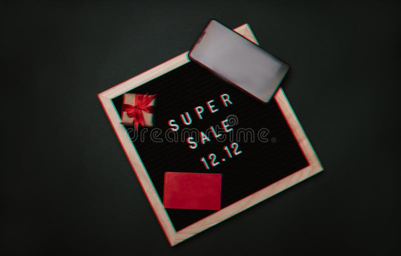 Glitch effect. The text of the 12.12 sale is on a letter board with a gift box, a credit card, a mini grocery cart and a phone. Design to promote the winter sale at the end of the year. Glitch effect. The text of the 12.12 sale is on a letter board with a gift box, a credit card, a mini grocery cart and a phone. Design to promote the winter sale at the end of the year