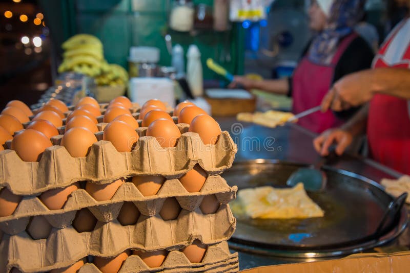 Egg for making an indian traditional food made of flour, crispy flat bread ,Blurred chef and mobile shop in Thailand night street food. Egg for making an indian traditional food made of flour, crispy flat bread ,Blurred chef and mobile shop in Thailand night street food.