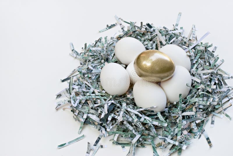 Nest of shredded money with the proverbial golden egg on top of white eggs. Nest of shredded money with the proverbial golden egg on top of white eggs.