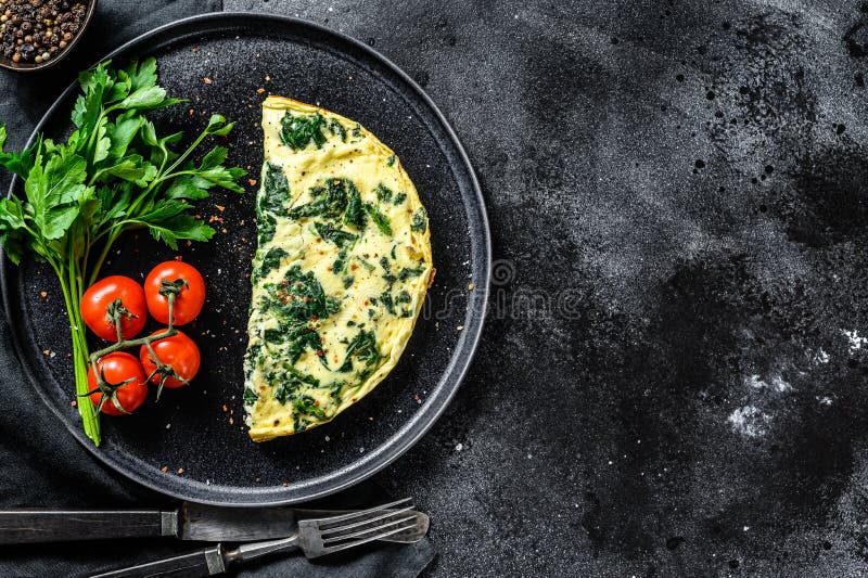 Egg Omelet with Spinach, Served on a Plate with Tomatoes. Black