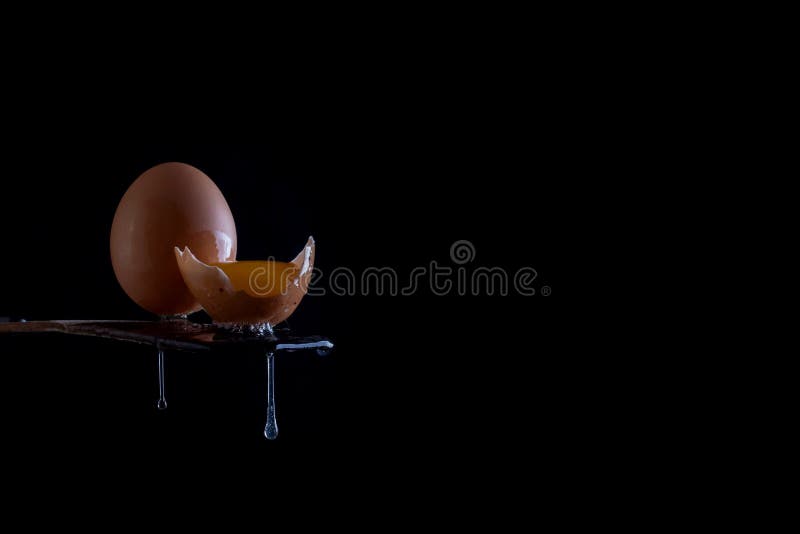 Egg with Yolk and Drops on the Edge of a Wooden Table. Stock Photo