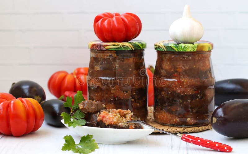 Eggplants in acute sauce of pepper, tomatoes and garlic in jars on the table. royalty free stock photo Eggplants in acute sauce of pepper, tomatoes and garlic in jars on the table. royalty free stock photo