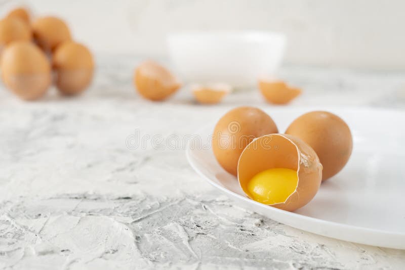 Eggs on the Table with Cracked in a Half One, Yolk and Protein in