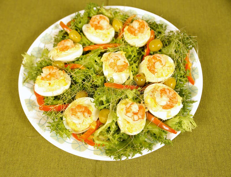 Filled eggs with shrimps served on a salad. Filled eggs with shrimps served on a salad