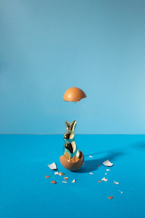 Eggshell with bunny rabbit. Creative copy space on pastel blue background. Minimal Easter holiday concept stock image