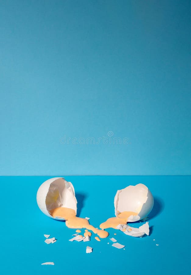 Eggshell with pastel pink paint. Creative copy space on blue background. Minimal Easter holiday concept stock image