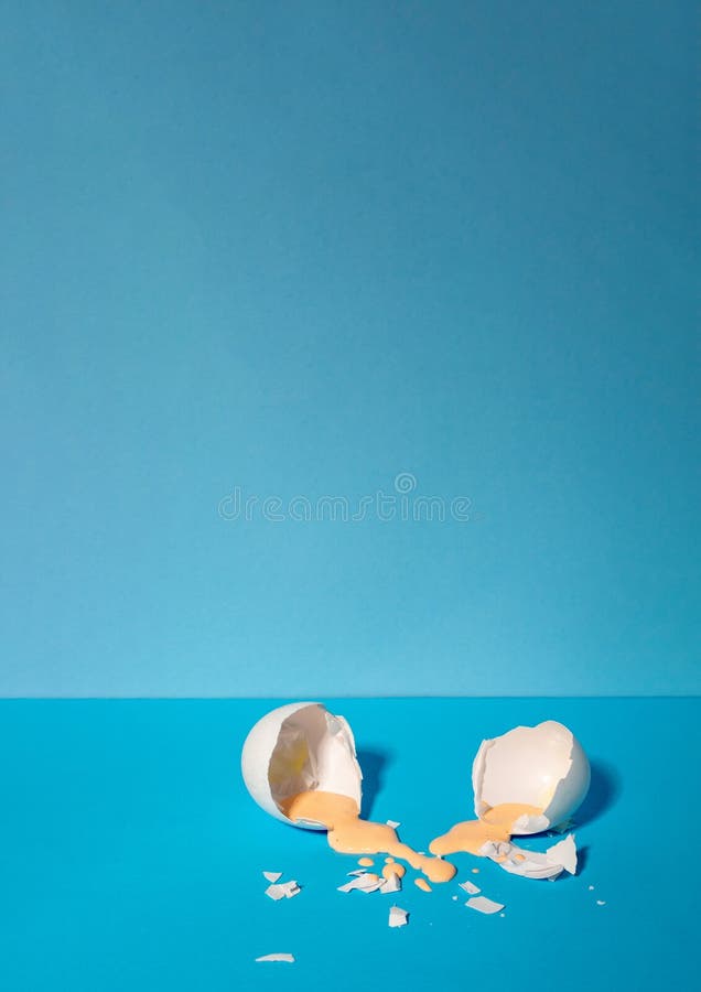 Eggshell with pastel pink paint. Creative copy space on blue background. Minimal Easter holiday concept royalty free stock photos