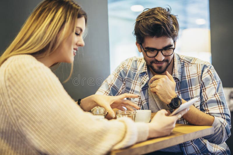 Ehepaare, die Mobiltelefon in einem Café benutzen lizenzfreie stockfotografie