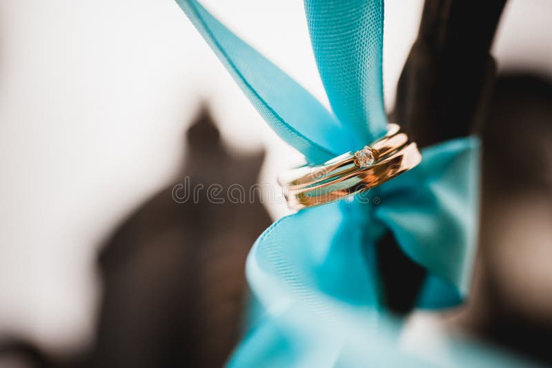 Wedding rings tied with ribbon on color background. Wedding rings tied with ribbon on color background