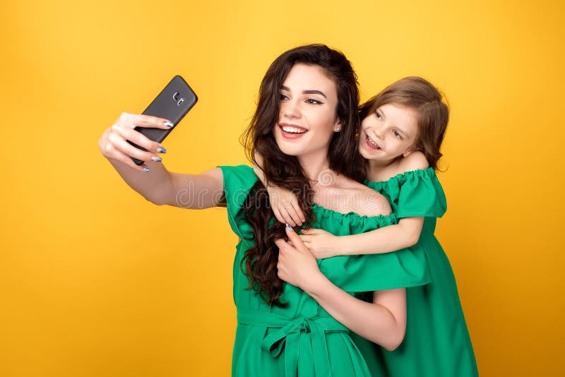 Ehrfürchtige Mutter mit der Tochter, die selfie nimmt lizenzfreie stockfotos Ehrfürchtige Mutter mit der Tochter, die selfie nimmt lizenzfreie stockfotos