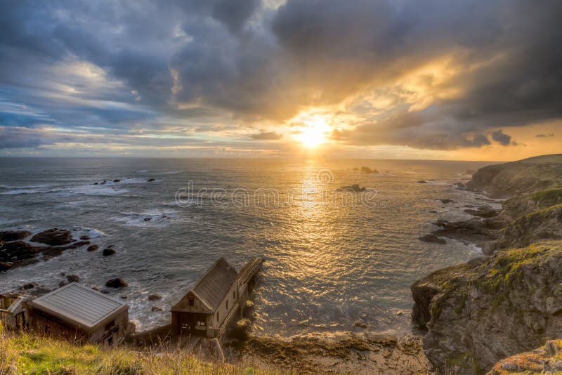 Dramtic sunset over Polpeor Cove at Lizard Point Cornwall England UK Europe. Dramtic sunset over Polpeor Cove at Lizard Point Cornwall England UK Europe