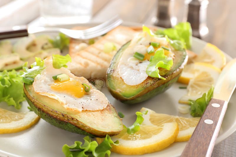 Eieren in avocado en plakken van geroosterd brood op plaat, close-up worden gebakken die stock foto's Eieren in avocado en plakken van geroosterd brood op plaat, close-up worden gebakken die stock foto's