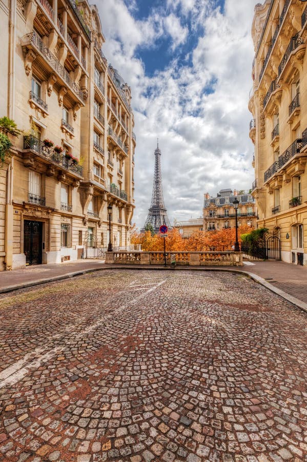 Eiffel Tower seen from the street in Paris, France. Cobblestone pavement