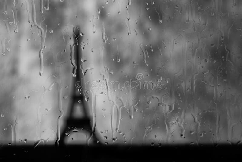 Eiffel tower seen through wet window in rain storm