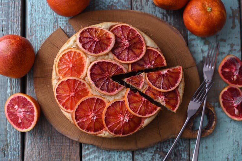 Eigengemaakte fruitcake De ronde die cake van de bloedsinaasappel op eiken raad wordt gesneden royalty-vrije stock foto Eigengemaakte fruitcake De ronde die cake van de bloedsinaasappel op eiken raad wordt gesneden royalty-vrije stock foto