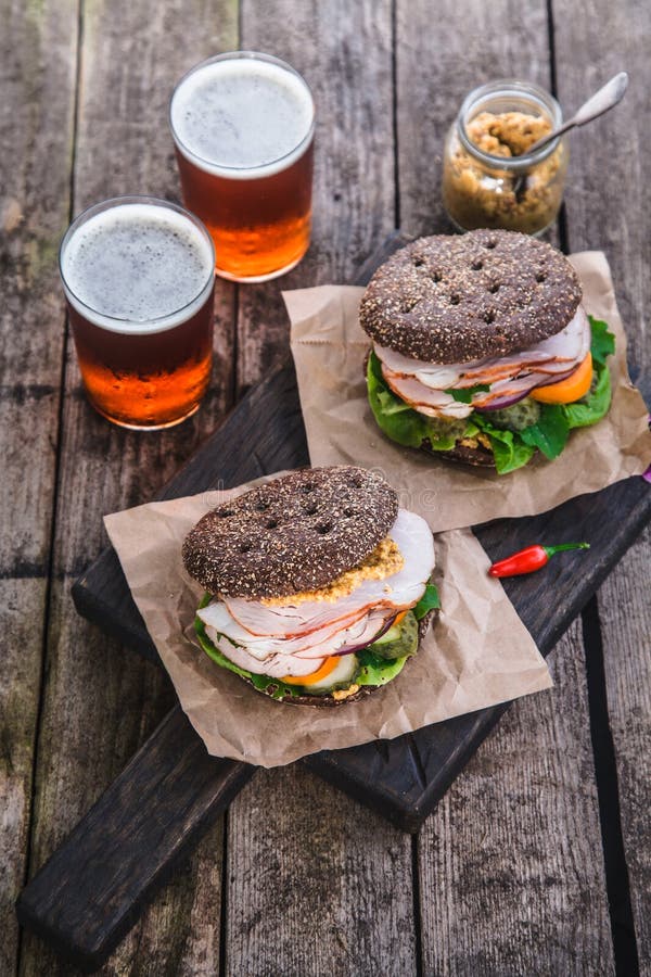 Eigengemaakte sandwich met ham en een glas bier op een oude achtergrond, hoogste mening stock foto Eigengemaakte sandwich met ham en een glas bier op een oude achtergrond, hoogste mening stock foto