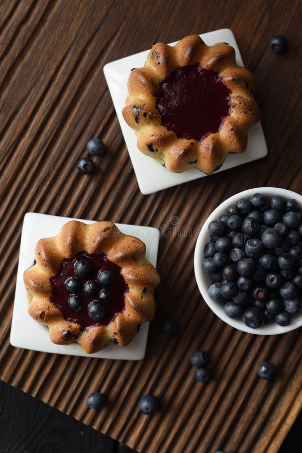 Eigengemaakte snoepjes Yummy cakes met jam en de wilde bosbessen op geribbelde eiken scherpe raads hoogste mening kopiëren ruimte royalty-vrije stock foto's Eigengemaakte snoepjes Yummy cakes met jam en de wilde bosbessen op geribbelde eiken scherpe raads hoogste mening kopiëren ruimte royalty-vrije stock foto's