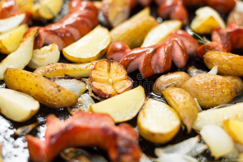 Eigengemaakte traditionele worsten en aardappels als achtergrond in een zwarte pan Vettig voedsel royalty-vrije stock afbeelding Eigengemaakte traditionele worsten en aardappels als achtergrond in een zwarte pan Vettig voedsel royalty-vrije stock afbeelding