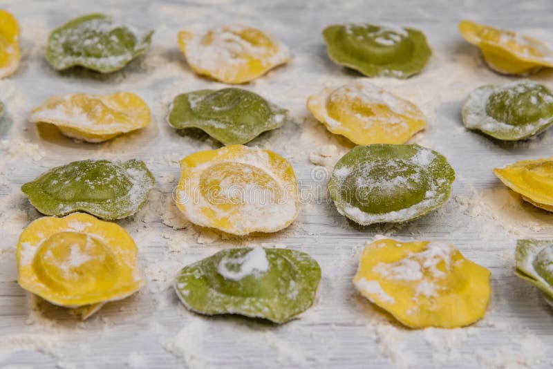 Homemade fresh Italian ravioli pasta on white wood table with flour close-up. Homemade fresh Italian ravioli pasta on white wood table with flour close-up