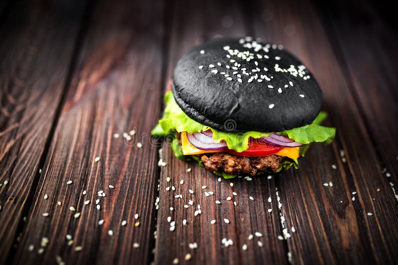 Eigengemaakte Zwarte Hamburger met Kaas Cheeseburger met zwart broodje o stock foto Eigengemaakte Zwarte Hamburger met Kaas Cheeseburger met zwart broodje o stock foto