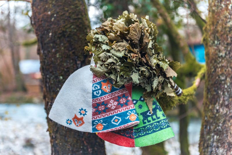 Oak Bath Broom with Two Banya Sauna Hats on the tree. Oak Bath Broom with Two Banya Sauna Hats on the tree