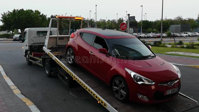 Ein Abschleppwagenautotransporter, Lastwagen, der ein Auto für die Reparatur an der Stadtstraße transportiert