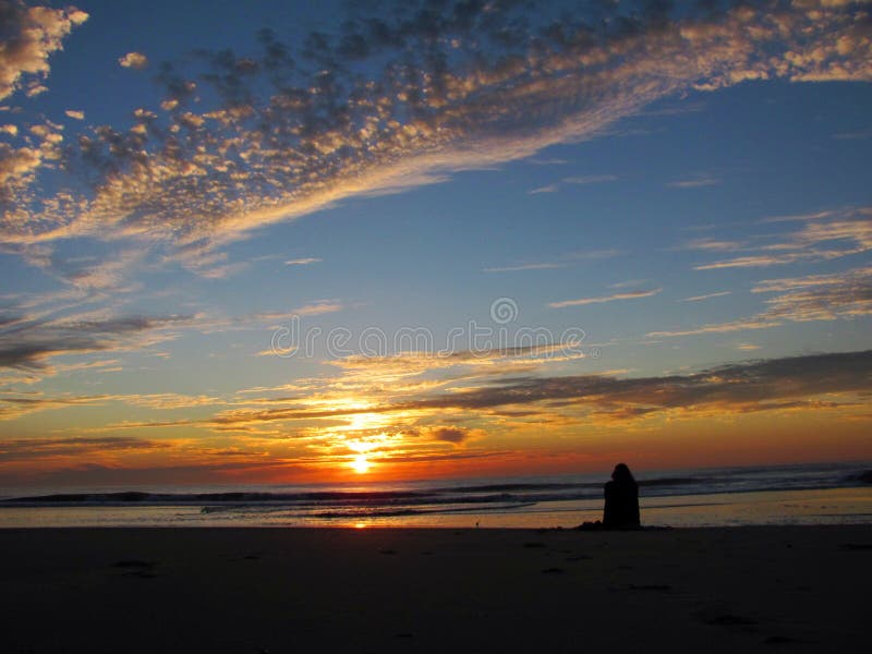 Ein aufpassender Sonnenaufgang des Mädchens auf dem Strand stockfotos Ein aufpassender Sonnenaufgang des Mädchens auf dem Strand stockfotos