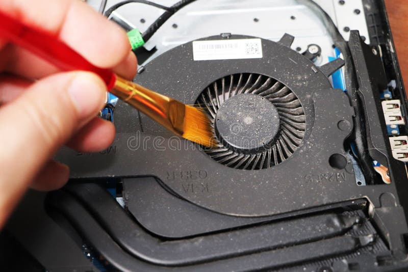 Ein Aussenseiter säubert eine Laptopkühlvorrichtung Verseuchtes Kühlsystem des Computers stockfoto Ein Aussenseiter säubert eine Laptopkühlvorrichtung Verseuchtes Kühlsystem des Computers stockfoto