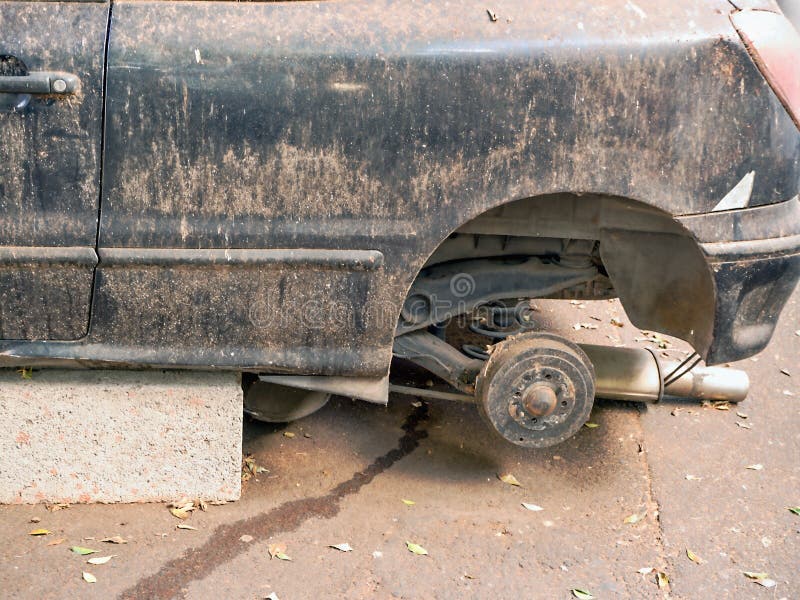 Ein Autowrack, das auf Steinen in ehemaligem dunkelblauem oder schwarz, die Räder errichtet wird, werden abgebaut stockfotografie Ein Autowrack, das auf Steinen in ehemaligem dunkelblauem oder schwarz, die Räder errichtet wird, werden abgebaut stockfotografie