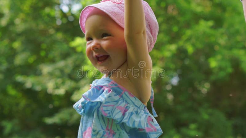 Ein Baby, das vor dem hintergrund der grünen Bäume lacht