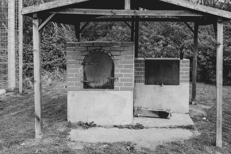 Ein Backofen steht draußen. Unter einem Holzdach steht ein Backofen für Brot