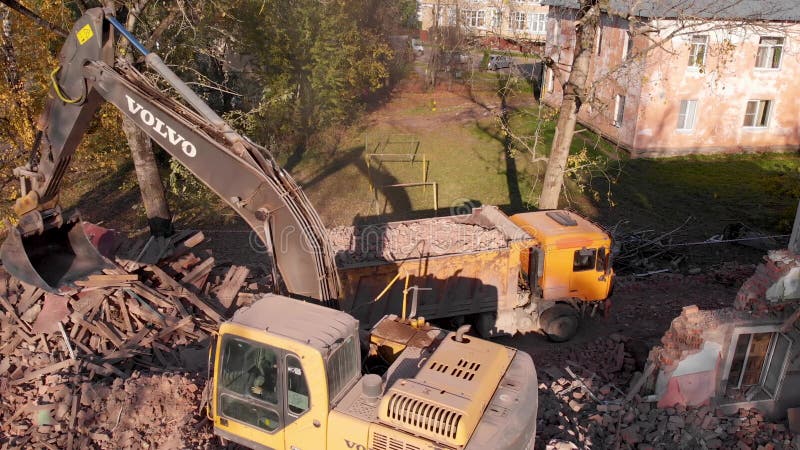 Ein Bagger die Trümmer eines zerstörten Gebäudes in einen Lastwagen.