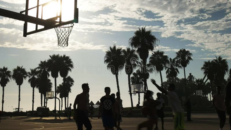 Ein Basketball-Spieler-Slam Dunk-Basketball an Venedig-Strand