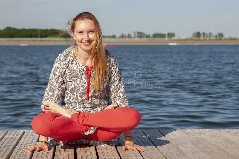Ein Bild einer h?bschen Frau, die Yoga am See tut lizenzfreie stockbilder Ein Bild einer h?bschen Frau, die Yoga am See tut lizenzfreie stockbilder