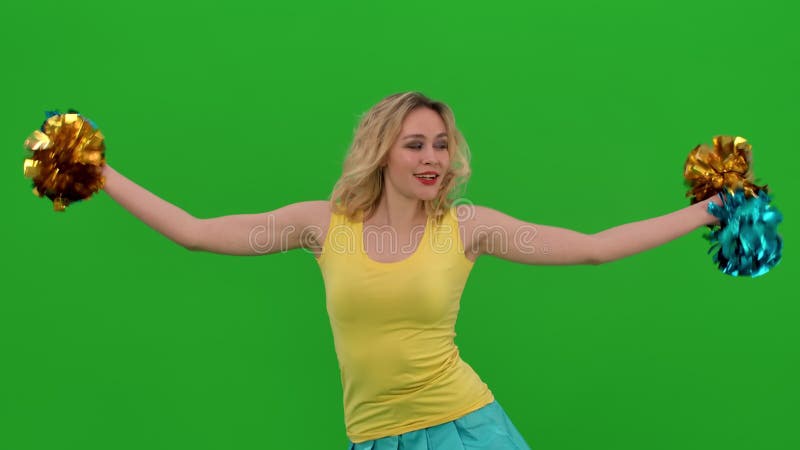 Ein cheerleader tanzt ein jubilant tanz mit pompoms anmutig duckt tut eine vertikale split. eine Blondine in einem gelben und stock video footage